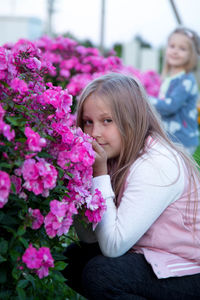Close-up of smiling girl sitting flowers