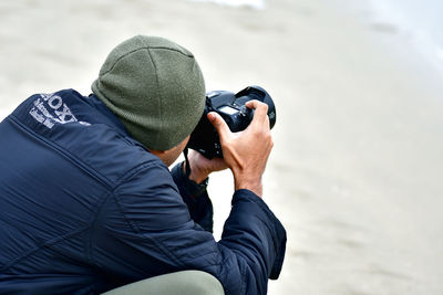 Close-up of man photographing against sky