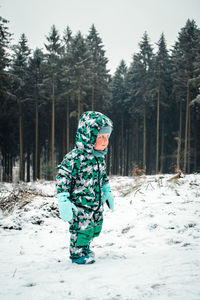 Boy playing with snow covered land