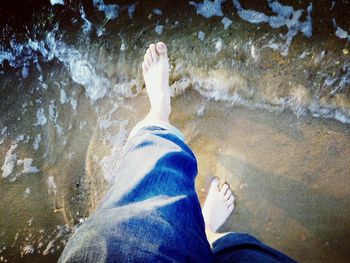 Low section of woman with legs in water