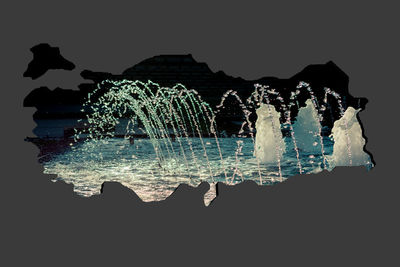 Illuminated fountain against sky at night