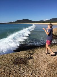 Full length of man on beach against clear sky