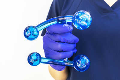Midsection of scientist holding stethoscope against white background