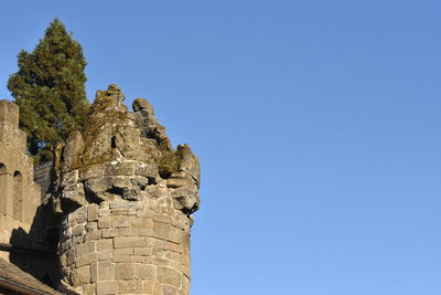 Low angle view of old ruin against clear blue sky