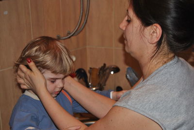 Mother covering ears of son in kitchen