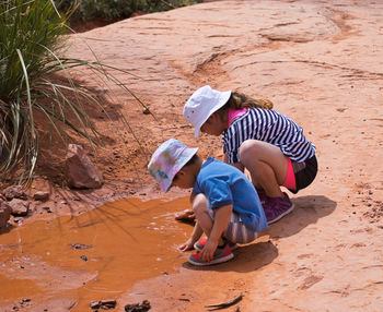 Siblings playing in mud