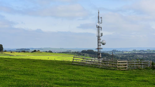 Electricity pylon on field against sky