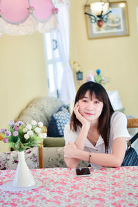 Portrait of young woman sitting at home