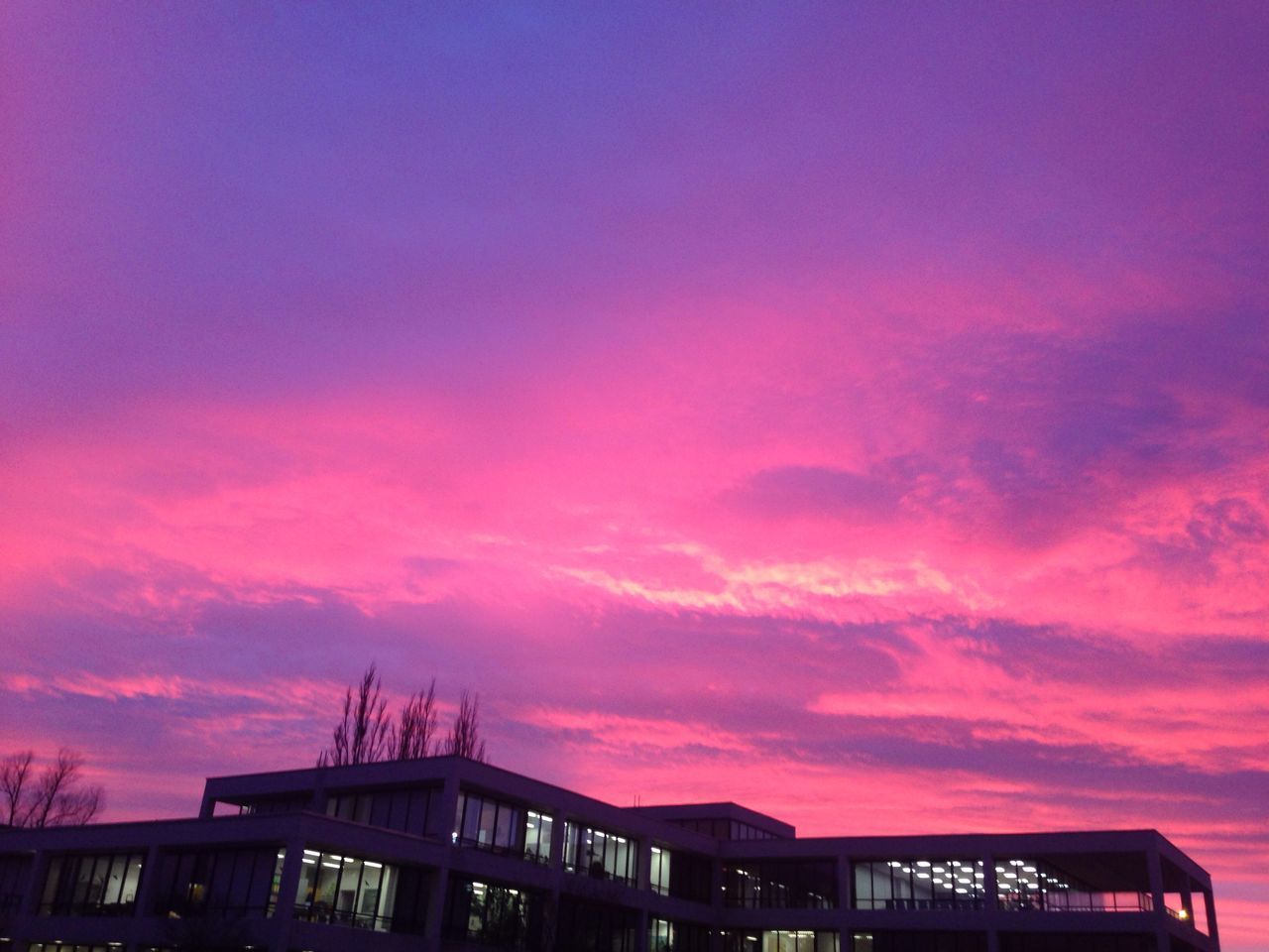 LOW ANGLE VIEW OF SILHOUETTE BUILDING AGAINST SUNSET SKY