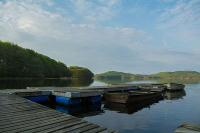 Boats moored in lake against sky