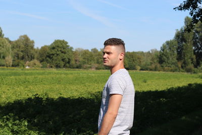 Young man standing on land against sky