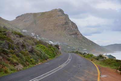 Road by mountain against sky