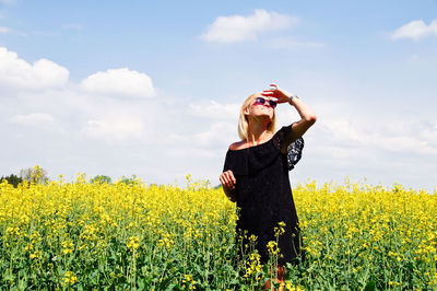 Full length of young woman standing in field