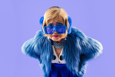 Portrait of woman wearing mask against blue background