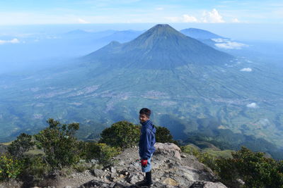 Man standing on mountain against sky