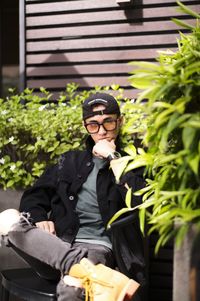 Portrait of young man using mobile phone while sitting on table