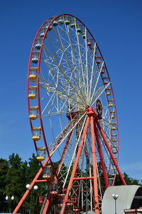 Low angle view of ferris wheel against blue sky