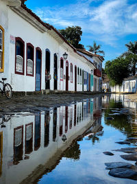 Reflection of building in canal against sky