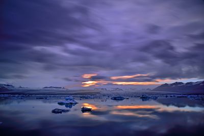 Scenic view of sea against dramatic sky during sunset