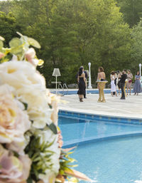 People at swimming pool against trees