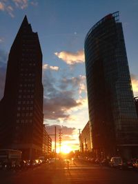 Low angle view of skyscrapers against sunset sky