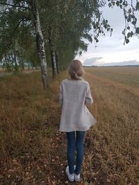 Rear view of girl standing on field