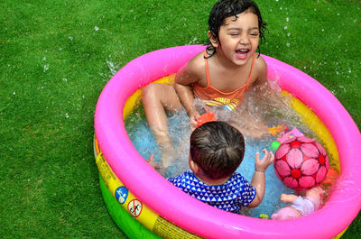High angle view of smiling boy playing in swimming pool