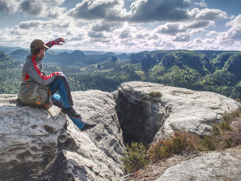 Male hiker meditating on flat place above valley. amazing view into pure nature. sunny spring day