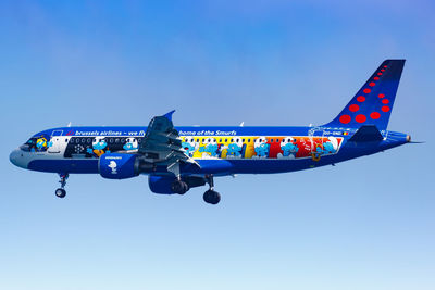 Low angle view of airplane against clear blue sky