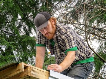 Low angle view of man working on roof