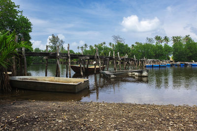 Boat moored in river against sky