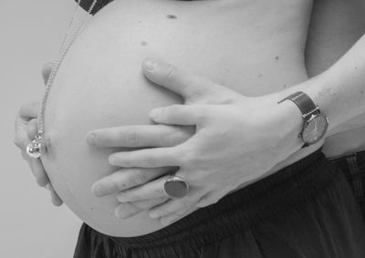 Midsection of woman touching mirror