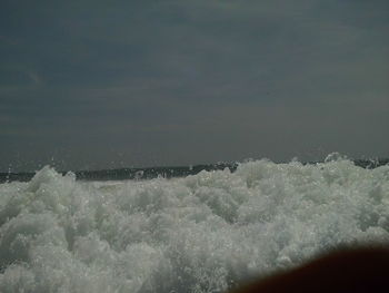 Water splashing in sea against sky