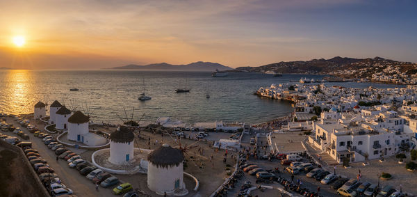 High angle view of city by sea against sky during sunset