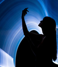 Side view of silhouette woman at illuminated nightclub
