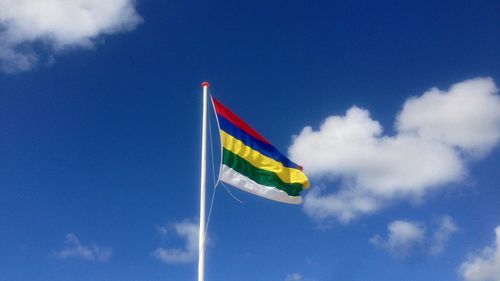 Low angle view of flag against blue sky