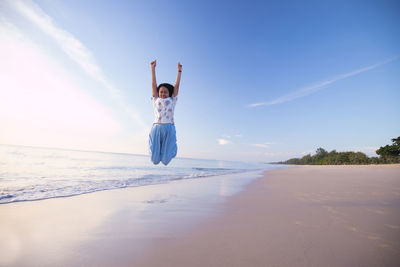 Rear view of person on beach against sky