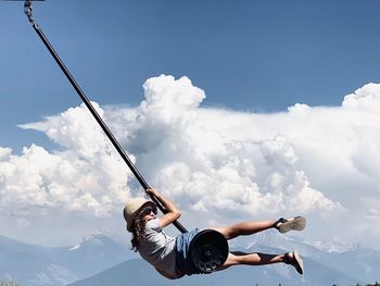 Low angle view of man exercising against sky