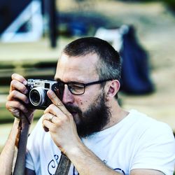 Close-up of man photographing through camera