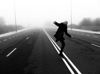 Full length of man skateboarding on road against sky