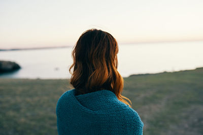 Rear view of woman against sky during sunset