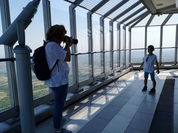 Mature woman photographing son while standing at observation point