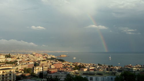 Aerial view of rainbow over cityscape against sky