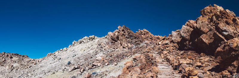 Low angle view of rocks against blue sky