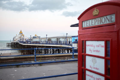 Eastbourne, east sussex, u.k. - red telephone box with eastbourne pier in the background