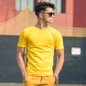 Portrait of young man standing against wall