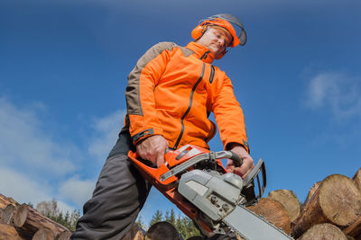 Low angle view of man working against sky