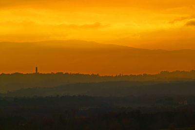 Scenic view of landscape against orange sky