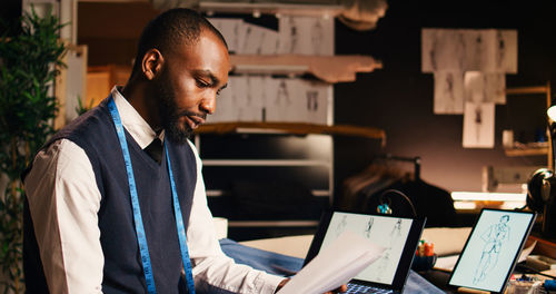 Young man using laptop while sitting in office