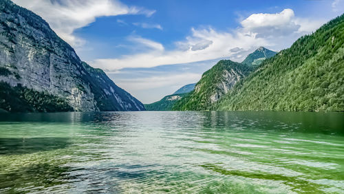 Scenic view of lake by mountains against sky